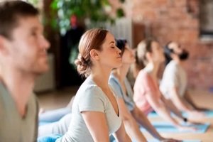 group of people doing yoga cobra pose at studio