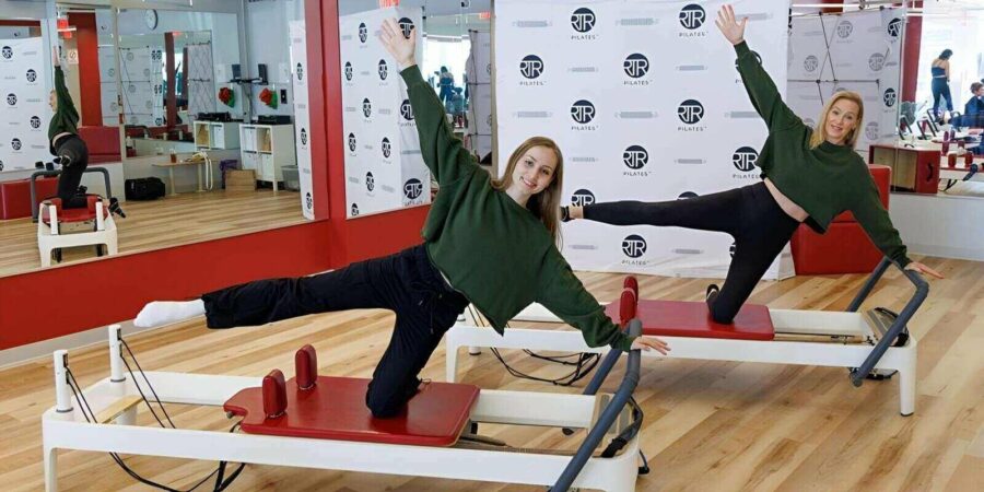 two DC pilates instructors doing reformer pilates
