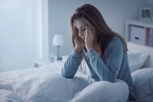 woman awake in the night, she is exhausted and suffering from insomnia