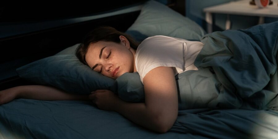young female sleeping peacefully in her bedroom at night after reformer pilates class