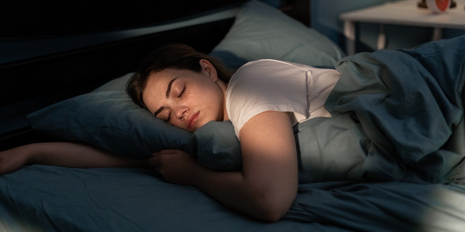 young female sleeping peacefully in her bedroom at night after reformer pilates class