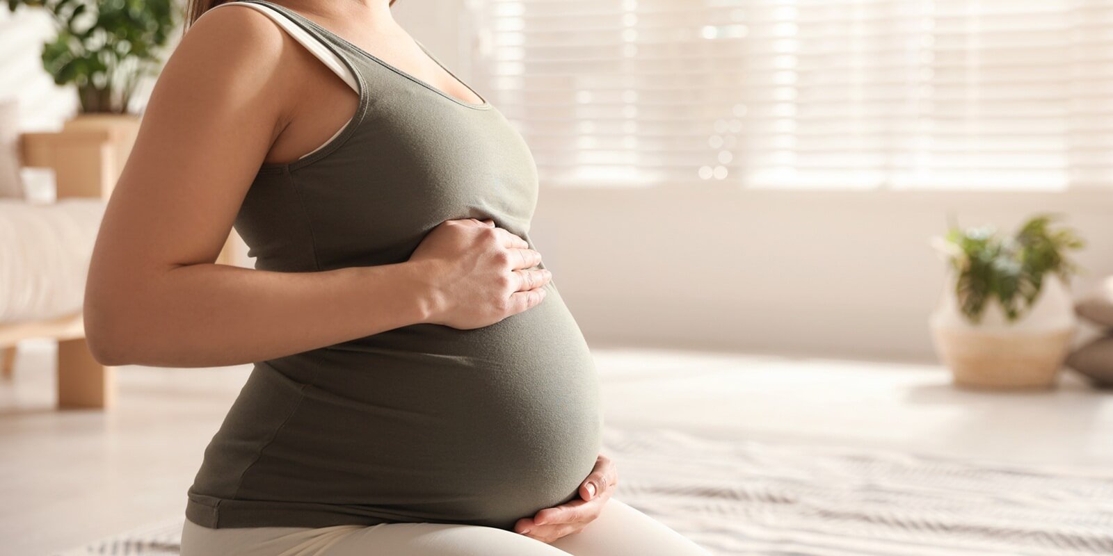 young pregnant woman practicing reformer pilates at home in Friendship Heights, MD